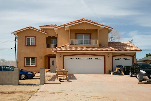 mediterranean / spanish-style home with a balcony, an attached garage, concrete driveway, and stucco siding