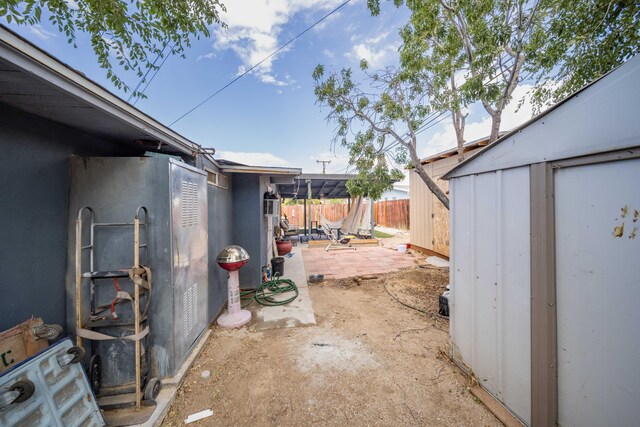 view of yard featuring a storage unit and a patio area