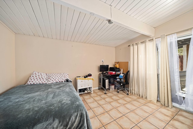 tiled bedroom with beamed ceiling and access to exterior