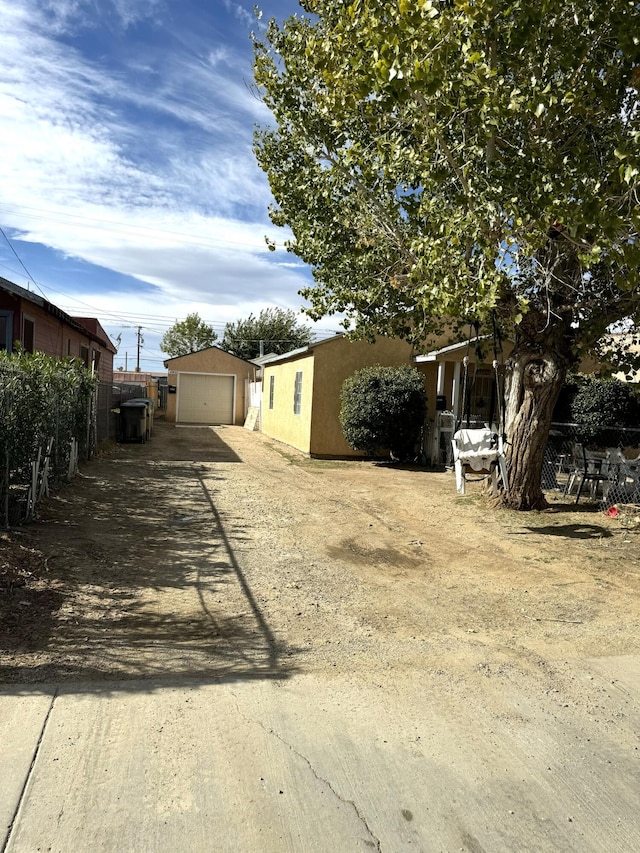 view of yard with an outdoor structure, fence, and a garage