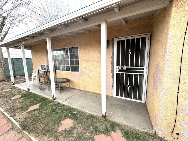 entrance to property with a patio area and stucco siding