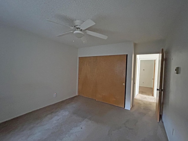 unfurnished bedroom with a textured ceiling, a closet, and ceiling fan