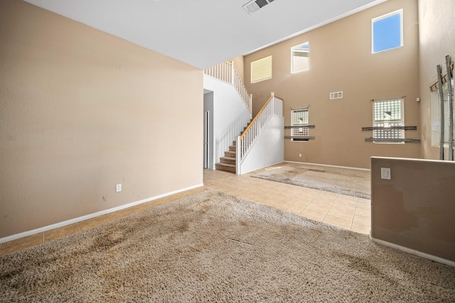 foyer entrance with light tile patterned floors and a high ceiling