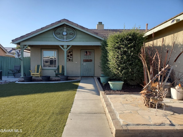 3657 Imperial Ave, Rosamond, CA 93560 - view of front of house with stucco siding, a chimney, and a porch