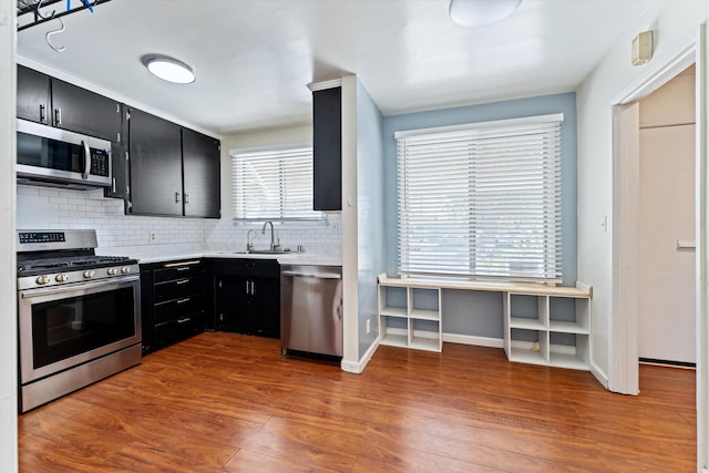 44129 Date Ave, Lancaster, CA 93534 - kitchen featuring appliances with stainless steel finishes, dark cabinets, light countertops, and decorative backsplash