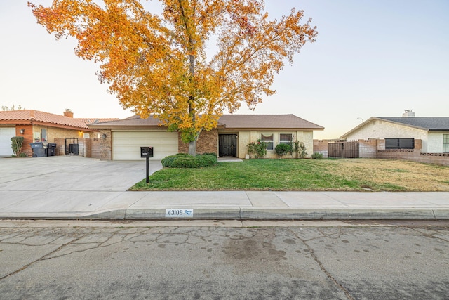 ranch-style home featuring a yard and a garage