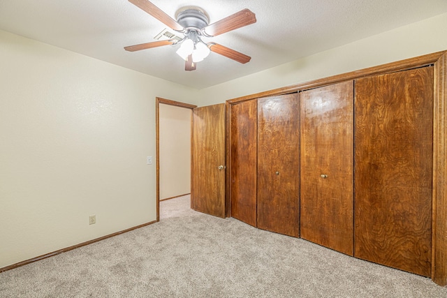 unfurnished bedroom with ceiling fan, a closet, and light colored carpet