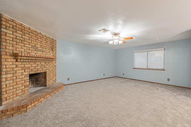 unfurnished living room with ceiling fan, carpet, a textured ceiling, and a brick fireplace