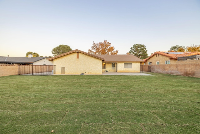 back of property with a lawn and a patio area