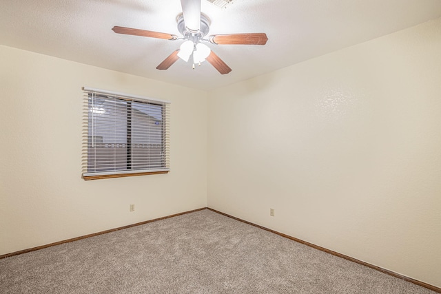 spare room with ceiling fan and light carpet