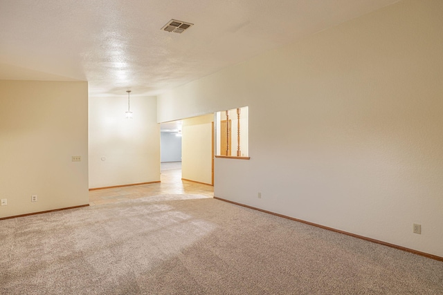 empty room featuring light carpet and a textured ceiling