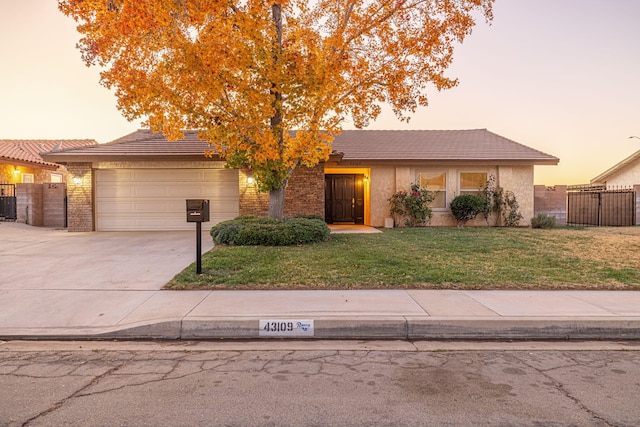 view of front of property featuring a lawn, central AC, and a garage