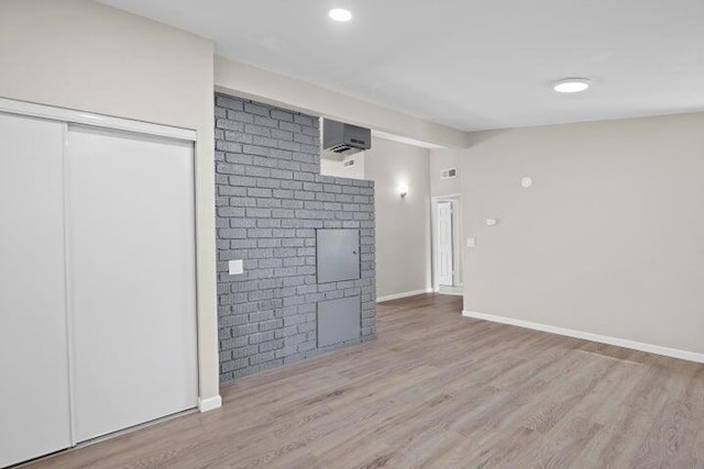 unfurnished living room with baseboards and wood finished floors