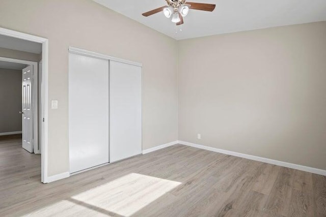 unfurnished bedroom with baseboards, a ceiling fan, a closet, and wood finished floors