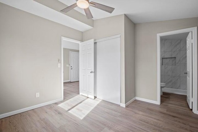unfurnished bedroom with baseboards, wood finished floors, and a closet