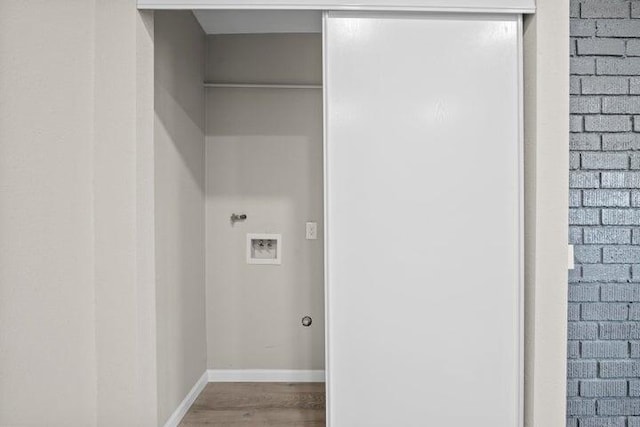 washroom with washer hookup, laundry area, baseboards, and wood finished floors