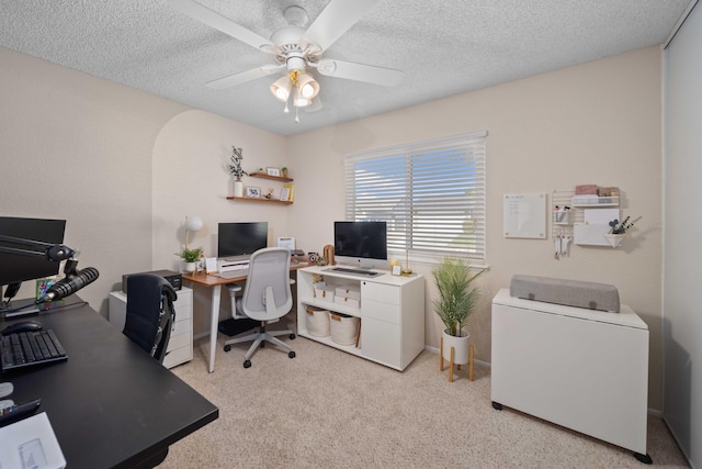 carpeted office featuring ceiling fan and a textured ceiling