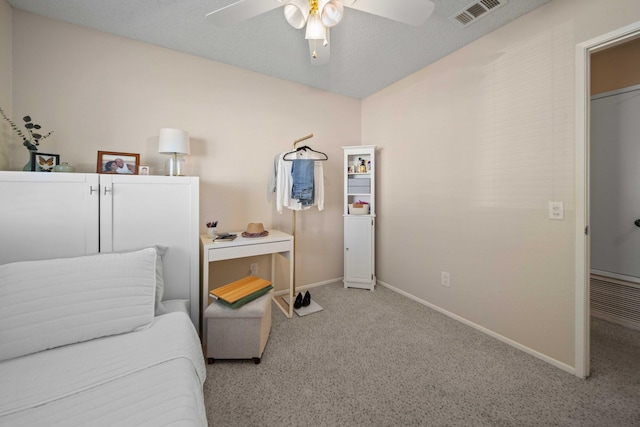 bedroom featuring light colored carpet, a textured ceiling, and ceiling fan