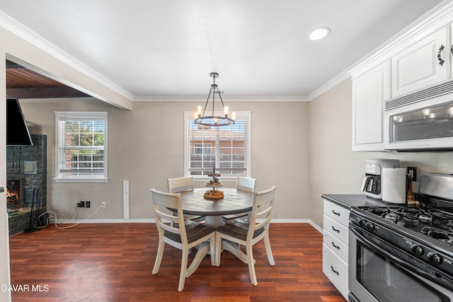 43249 W 42nd St, Lancaster, CA 93536 - dining space with dark wood finished floors, a chandelier, a fireplace, crown molding, and recessed lighting