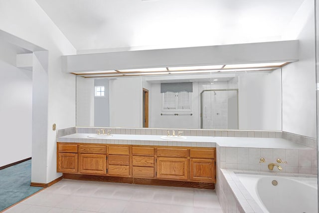 full bathroom featuring a garden tub, a stall shower, double vanity, and a sink