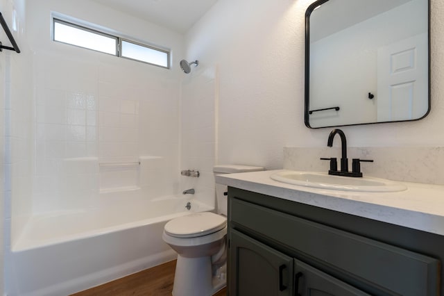 full bathroom featuring hardwood / wood-style flooring, shower / washtub combination, vanity, and toilet