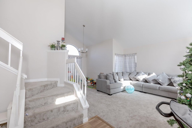 interior space featuring carpet flooring, high vaulted ceiling, and a chandelier