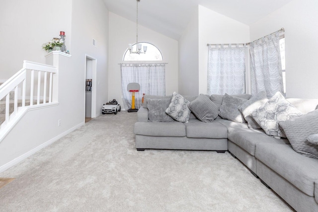 living room featuring carpet, high vaulted ceiling, and an inviting chandelier