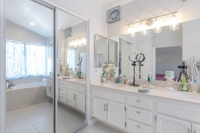 bathroom with tile patterned floors, vanity, a relaxing tiled tub, and vaulted ceiling