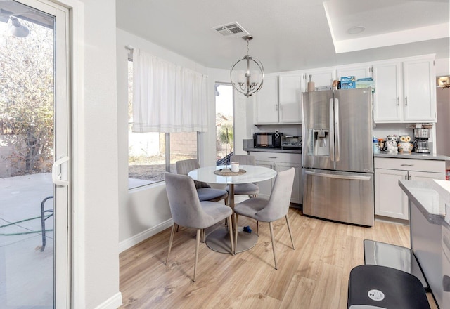 dining space featuring plenty of natural light, a chandelier, and light wood-type flooring