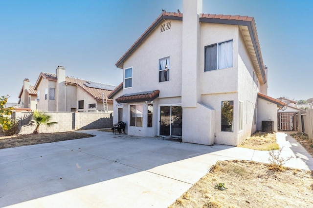 rear view of property with cooling unit and a patio