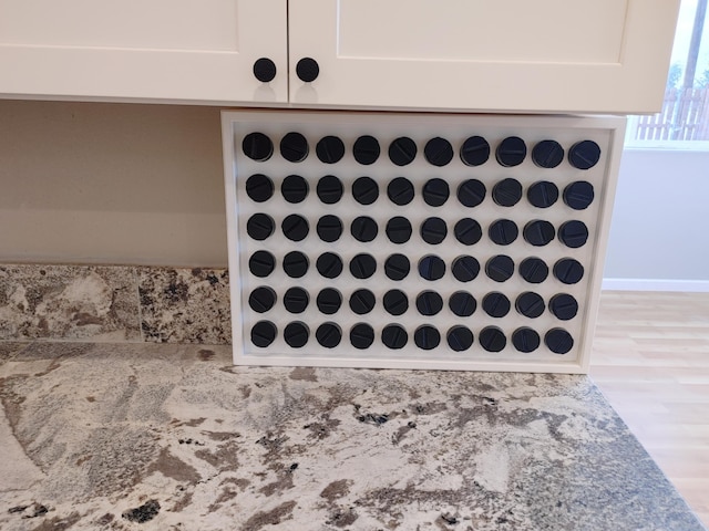 room details featuring white cabinetry and light stone counters