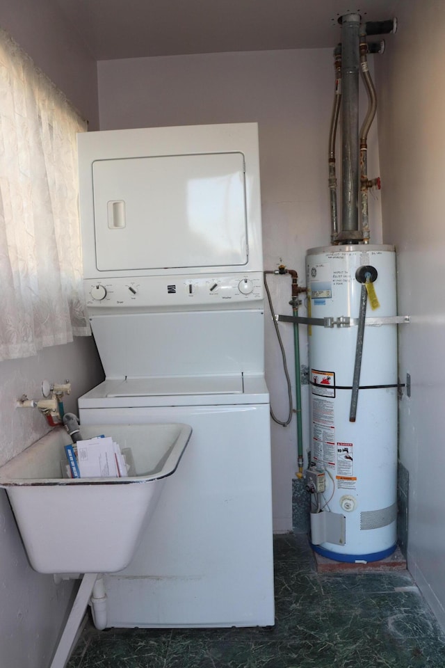 clothes washing area featuring stacked washing maching and dryer and strapped water heater