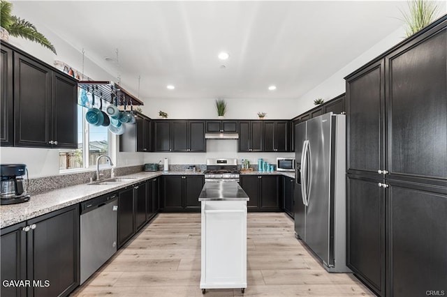 2436 Lugar Bonito Ct, Rosamond, CA 93560 - kitchen with appliances with stainless steel finishes, under cabinet range hood, light wood finished floors, a kitchen island, and recessed lighting