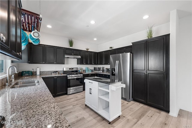 2436 Lugar Bonito Ct, Rosamond, CA 93560 - kitchen featuring appliances with stainless steel finishes, under cabinet range hood, light stone counters, dark cabinets, and open shelves