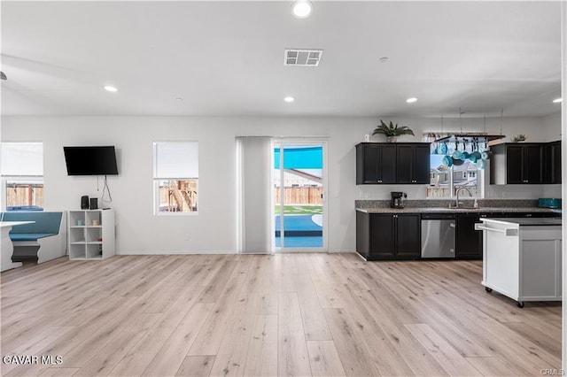 2436 Lugar Bonito Ct, Rosamond, CA 93560 - kitchen featuring dishwasher, open floor plan, dark cabinetry, light wood-type flooring, and recessed lighting