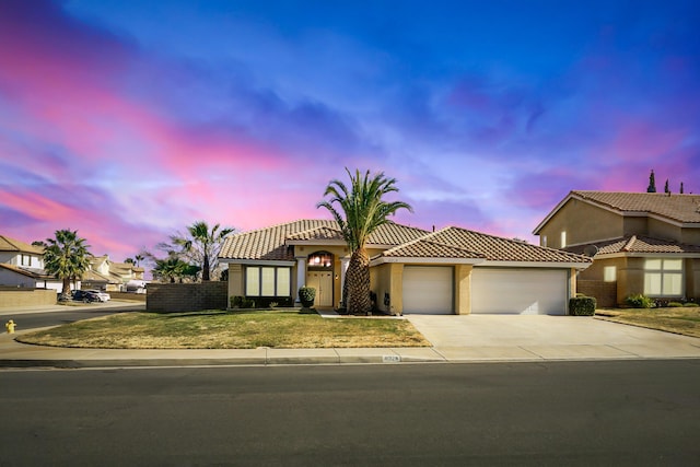 mediterranean / spanish house with a garage and a yard