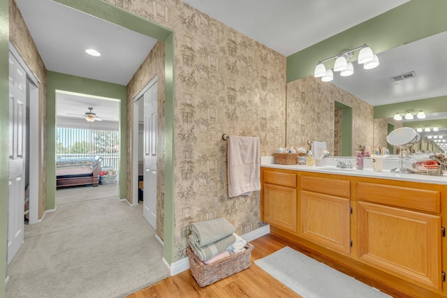 38360 Wakefield Pl, Palmdale, CA 93551 - bathroom with connected bathroom, vanity, wood finished floors, baseboards, and wallpapered walls