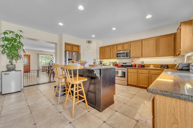 38360 Wakefield Pl, Palmdale, CA 93551 - kitchen with stainless steel appliances, a sink, a kitchen breakfast bar, recessed lighting, and a center island
