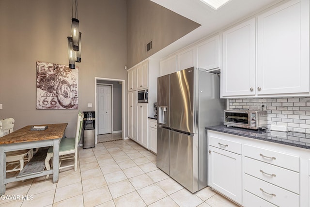 6015 Country Ln, Quartz Hill, CA 93536 - kitchen featuring stainless steel appliances, a high ceiling, light tile patterned floors, backsplash, and white cabinets