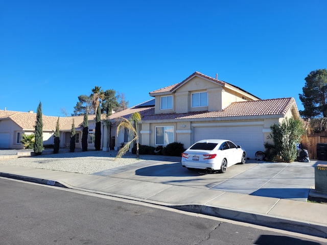 view of front of property with a garage, concrete driveway, a tile roof, and stucco siding