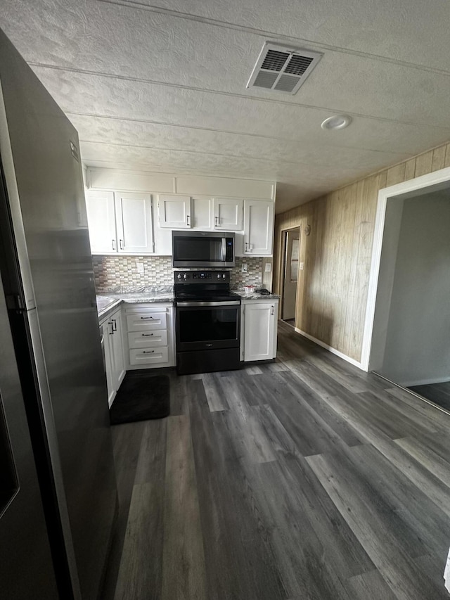 kitchen featuring white cabinets, backsplash, stainless steel appliances, and dark wood-type flooring