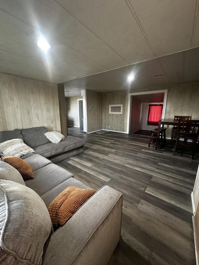 living room featuring wood walls and dark wood-type flooring