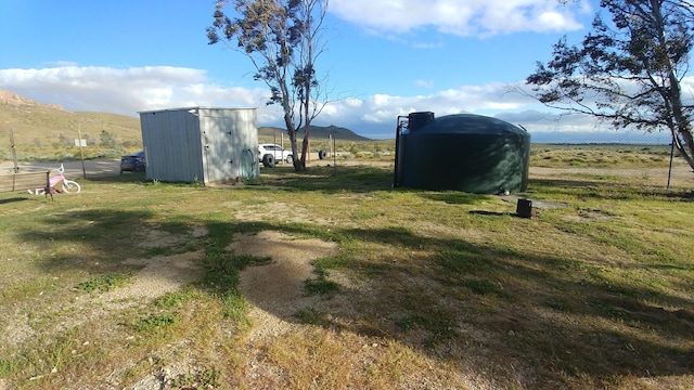 view of yard with a mountain view, a rural view, and a shed