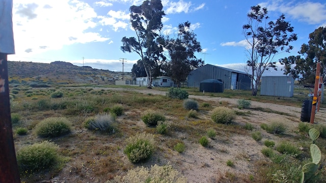 view of yard featuring a mountain view and an outdoor structure