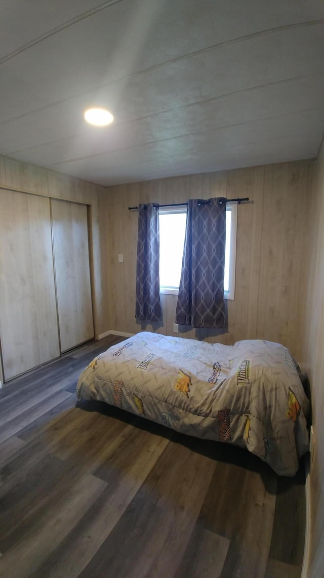 bedroom with wooden walls and hardwood / wood-style floors