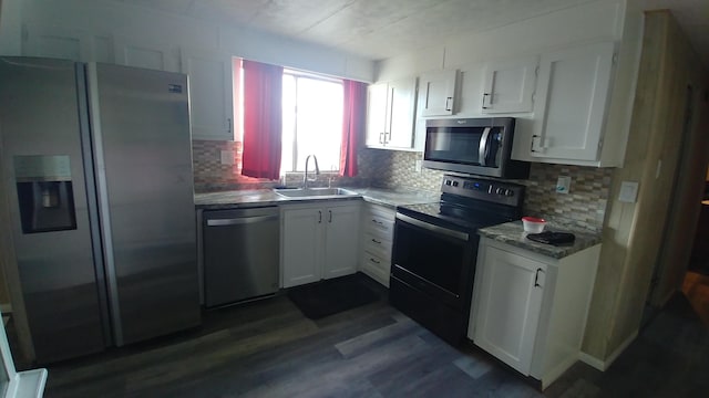 kitchen with tasteful backsplash, white cabinetry, sink, and stainless steel appliances