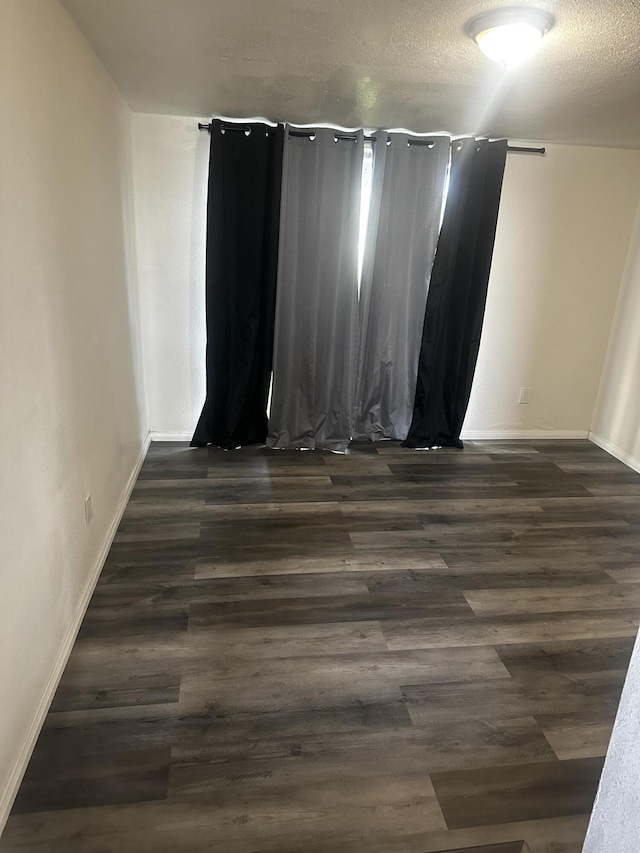 empty room featuring dark hardwood / wood-style flooring and a textured ceiling