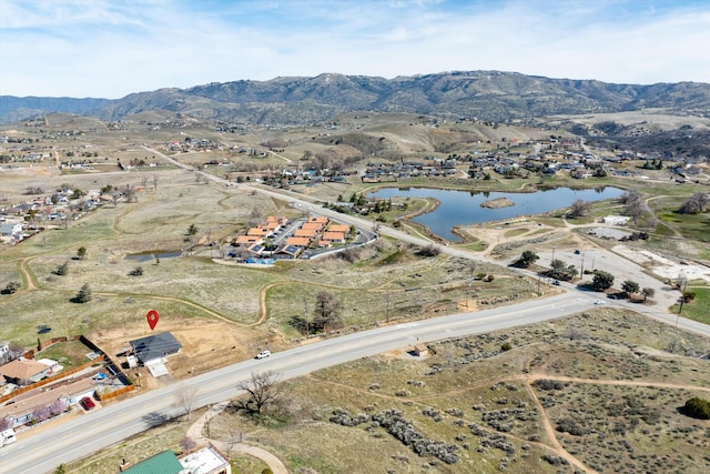 birds eye view of property with a water and mountain view