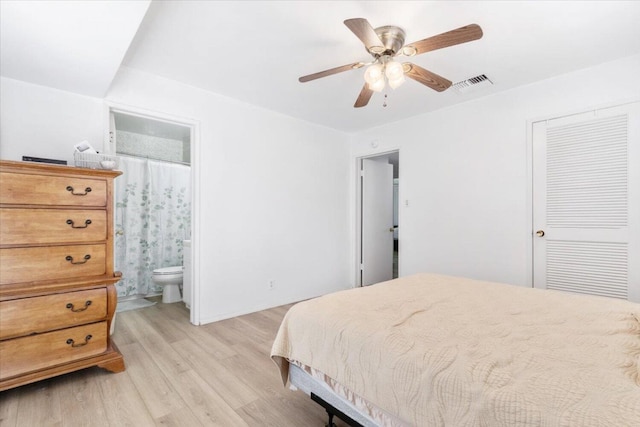 bedroom featuring ensuite bath, a closet, ceiling fan, and light wood-type flooring