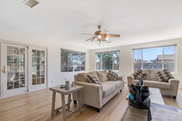 living room featuring ceiling fan, a healthy amount of sunlight, and light hardwood / wood-style floors